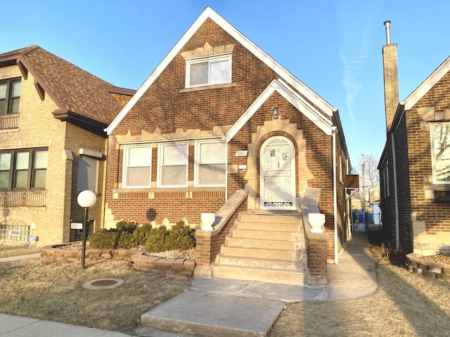 tudor house featuring brick siding