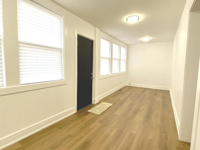 empty room featuring wood finished floors and baseboards