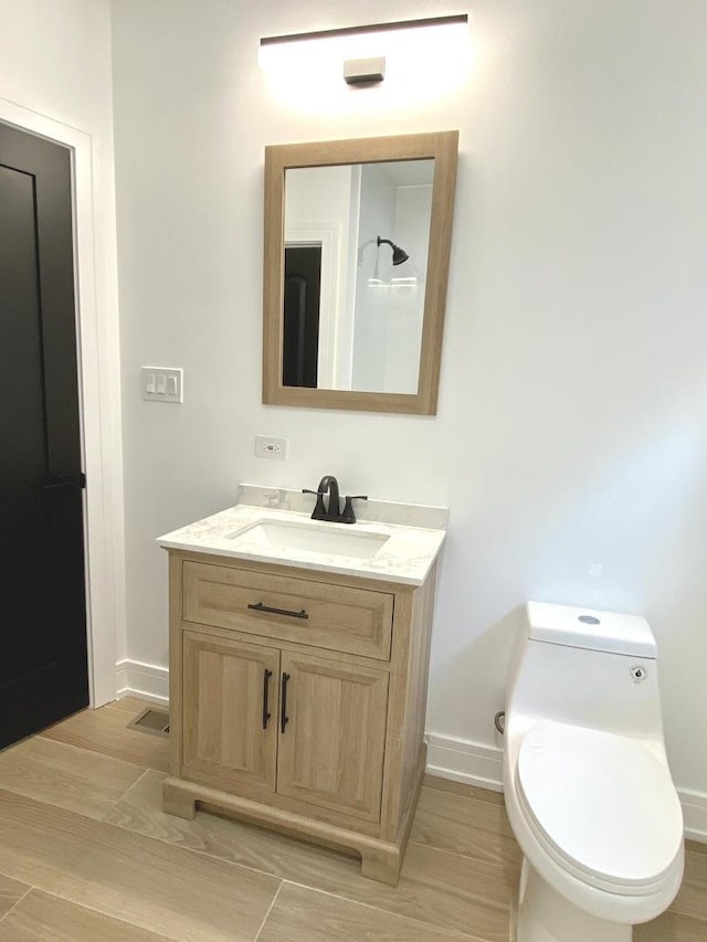 bathroom with vanity, toilet, and baseboards