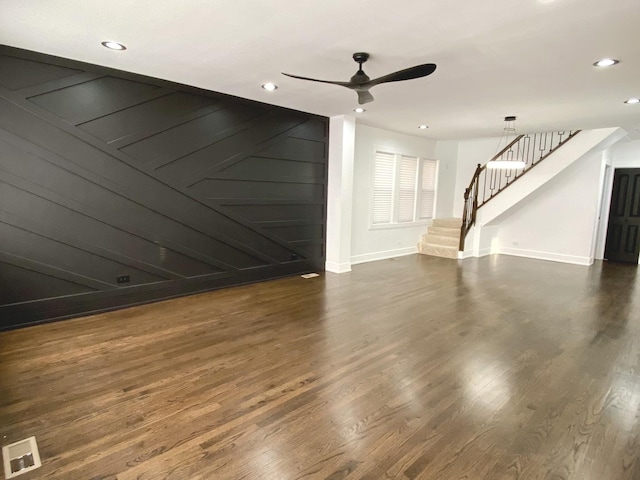 unfurnished living room with a ceiling fan, recessed lighting, baseboards, stairs, and wood finished floors
