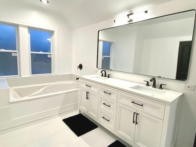 bathroom with a sink, double vanity, lofted ceiling, and a bath