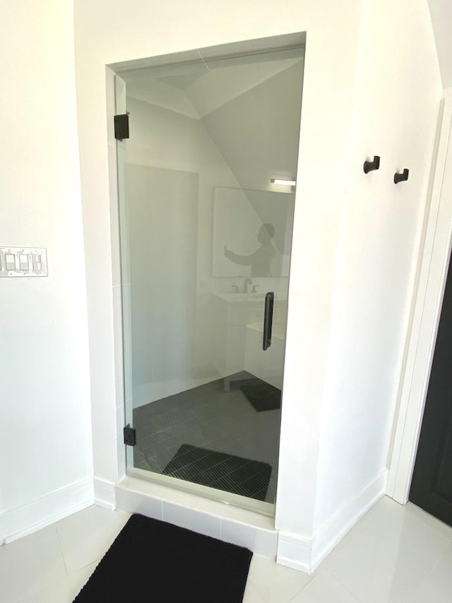 full bathroom with baseboards, tile patterned flooring, a shower stall, and a sink