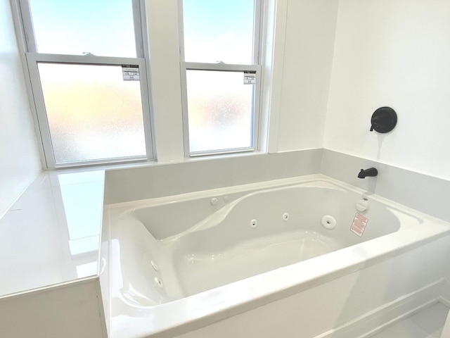 full bathroom with a tub with jets