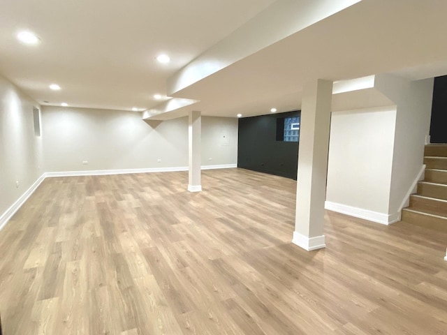 finished below grade area with light wood-style flooring, stairs, baseboards, and recessed lighting