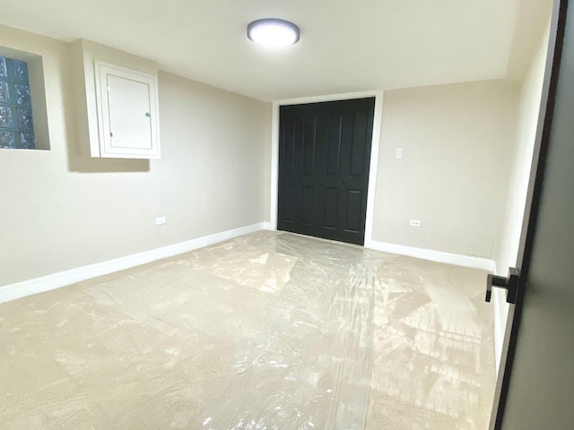 unfurnished bedroom featuring light carpet and baseboards