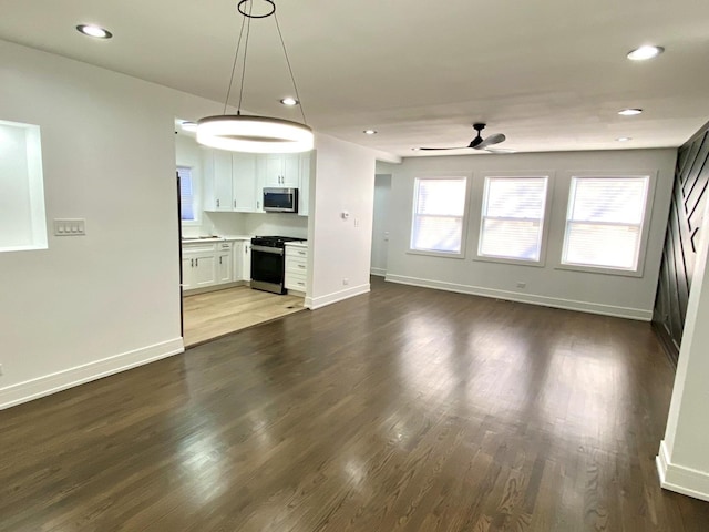 interior space featuring recessed lighting, baseboards, a ceiling fan, and dark wood-style floors