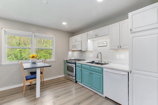 4603 Bonner Dr, Mchenry, IL 60050 - kitchen with white appliances, a sink, blue cabinets, light wood-style flooring, and light countertops