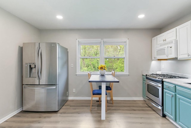 4603 Bonner Dr, Mchenry, IL 60050 - kitchen featuring appliances with stainless steel finishes, blue cabinets, light wood finished floors, light countertops, and white cabinetry