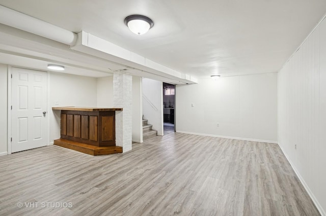 finished basement featuring baseboards, stairway, and wood finished floors
