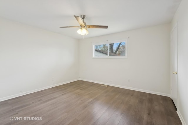 empty room featuring baseboards, a ceiling fan, and wood finished floors