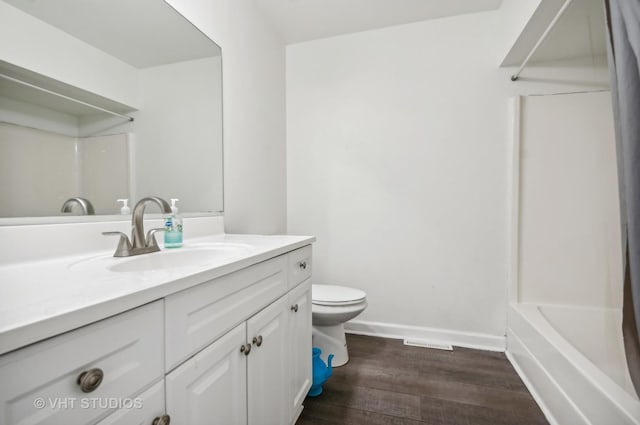 bathroom featuring toilet, wood finished floors, visible vents, baseboards, and vanity
