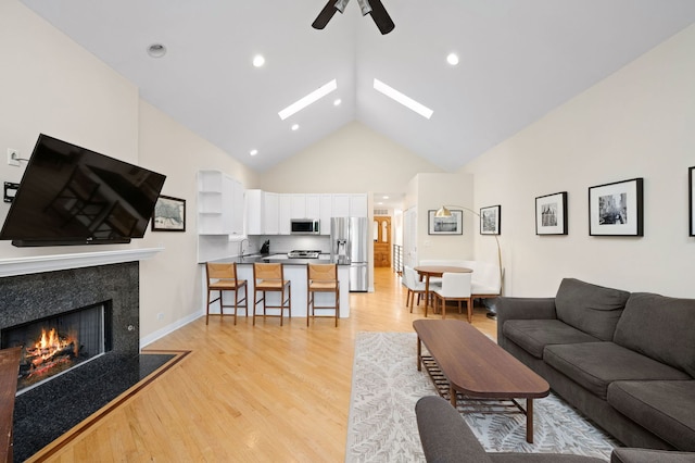 2033 W Rice St Unit 3, Chicago, IL 60622 - living area featuring high vaulted ceiling, ceiling fan, a premium fireplace, light wood-style floors, and a skylight