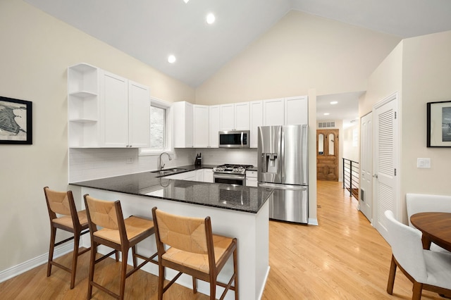 2033 W Rice St Unit 3, Chicago, IL 60622 - kitchen with stainless steel appliances, a sink, open shelves, a peninsula, and white cabinetry