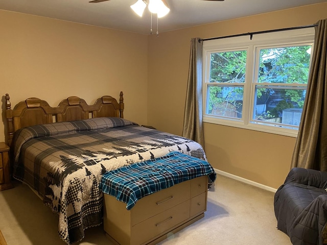 bedroom featuring baseboards, light carpet, and a ceiling fan