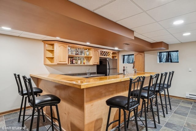 2020 Saint Andrews Dr, Plainfield, IL 60586 - indoor wet bar with freestanding refrigerator, a drop ceiling, dark stone finish flooring, a baseboard radiator, and recessed lighting