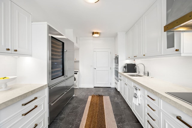 1040 N Lake Shore Dr Unit 4C, Chicago, IL 60611 - kitchen featuring exhaust hood, white cabinets, light countertops, backsplash, and washer / clothes dryer