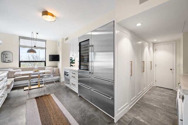 1040 N Lake Shore Dr Unit 4C, Chicago, IL 60611 - kitchen featuring built in refrigerator, light countertops, white cabinets, and hanging light fixtures