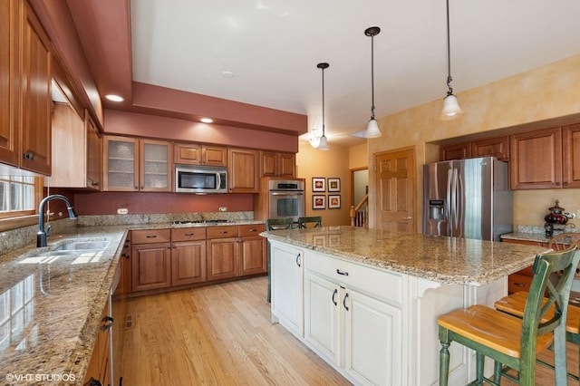 1373 Notre Dame Dr, Lemont, IL 60439 - kitchen featuring appliances with stainless steel finishes, a sink, brown cabinetry, and a center island