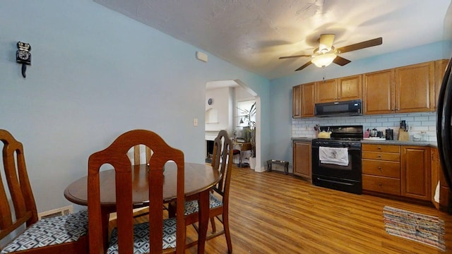 1013 W Springfield Ave, Champaign, IL 61821 - kitchen with black appliances, ceiling fan, arched walkways, and brown cabinetry