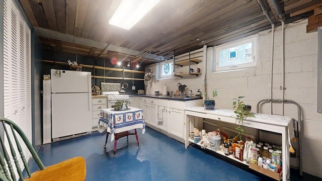 1013 W Springfield Ave, Champaign, IL 61821 - kitchen with white appliances, concrete flooring, white cabinets, and concrete block wall