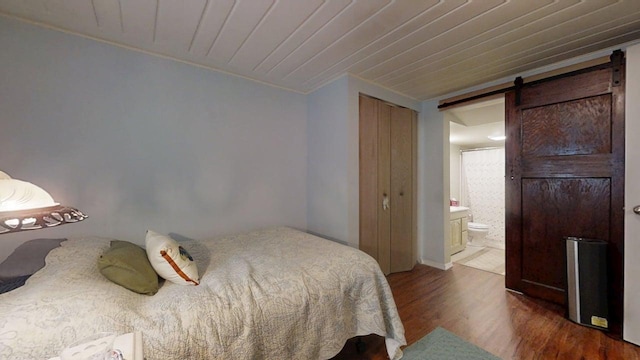 1013 W Springfield Ave, Champaign, IL 61821 - bedroom with a barn door, wood finished floors, connected bathroom, ornamental molding, and wood ceiling