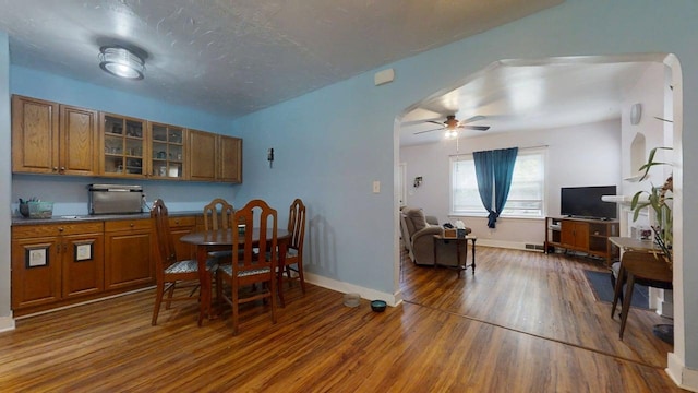 1013 W Springfield Ave, Champaign, IL 61821 - dining area with wood finished floors, arched walkways, ceiling fan, and baseboards