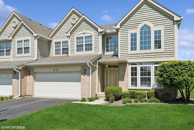 62 Andover Cir, Northbrook, IL 60062 - townhome / multi-family property with a front lawn, an attached garage, asphalt driveway, and brick siding
