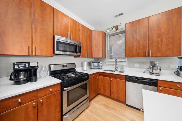 2158 N Natchez Ave Unit 1N, Chicago, IL 60707 - kitchen with a sink, stainless steel appliances, visible vents, light countertops, and light wood-style floors