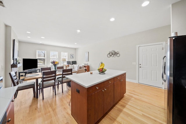2158 N Natchez Ave Unit 1N, Chicago, IL 60707 - kitchen featuring freestanding refrigerator, a center island, visible vents, light countertops, and light wood-type flooring
