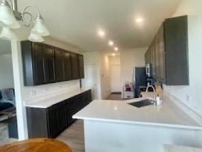 kitchen featuring a sink, a peninsula, and light countertops