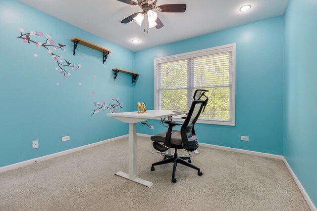 carpeted home office with a ceiling fan and baseboards
