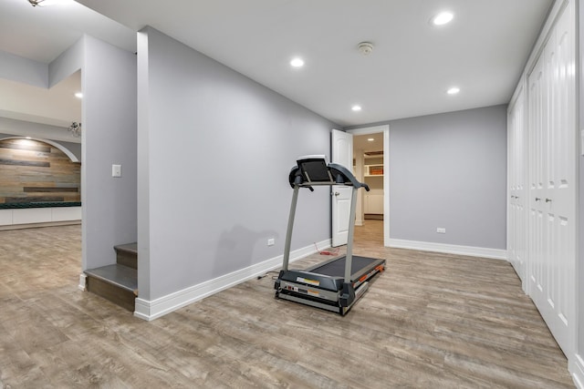 exercise area with wood finished floors, recessed lighting, and baseboards