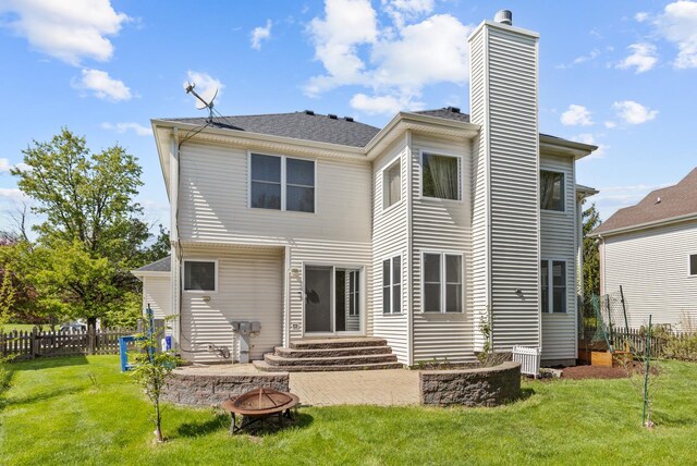 rear view of property featuring an outdoor fire pit, a chimney, entry steps, and a shingled roof