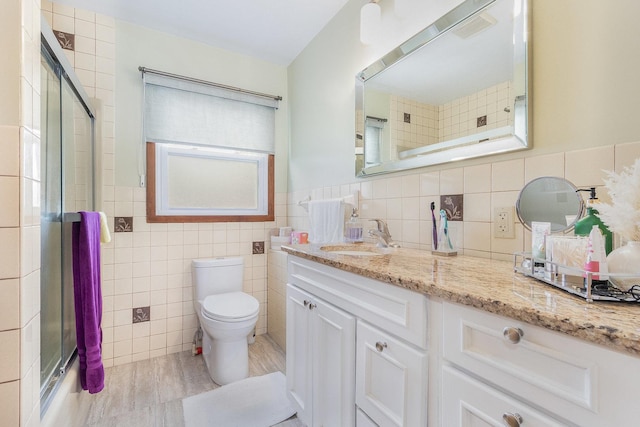411 E 2nd St, Lockport, IL 60441 - bathroom featuring tile walls, an enclosed shower, toilet, vanity, and wood finished floors