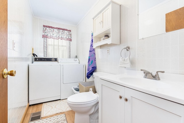 411 E 2nd St, Lockport, IL 60441 - bathroom featuring washing machine and clothes dryer, vanity, ornamental molding, toilet, and wood finished floors