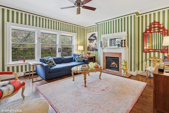 living area featuring wallpapered walls, baseboards, and ceiling fan