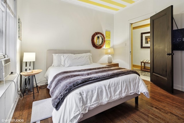 bedroom featuring crown molding and wood finished floors