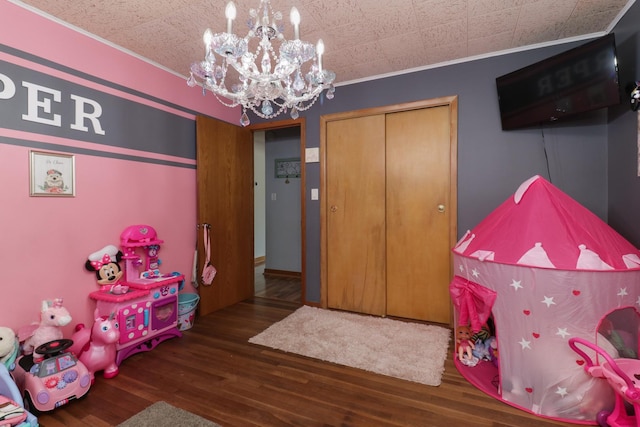 game room featuring a chandelier, wood finished floors, and crown molding