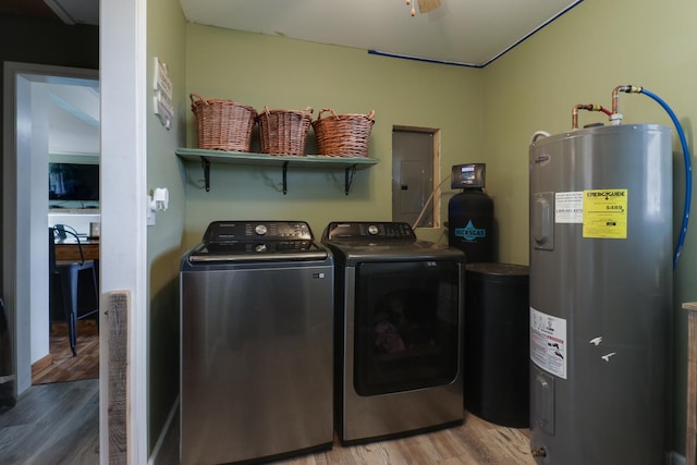 laundry area with electric water heater, electric panel, washer and dryer, and light wood-style floors