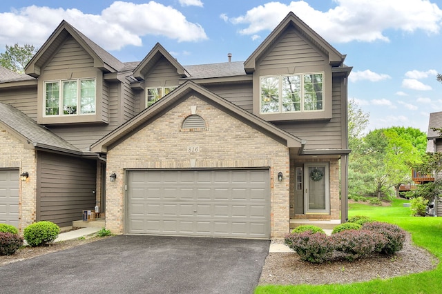 view of front of property with driveway, brick siding, an attached garage, and roof with shingles