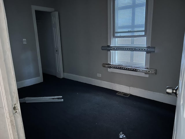 unfurnished room featuring baseboards and visible vents