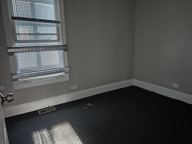 spare room featuring baseboards and visible vents