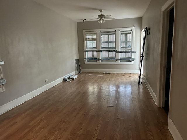 spare room featuring ceiling fan, baseboards, and wood finished floors