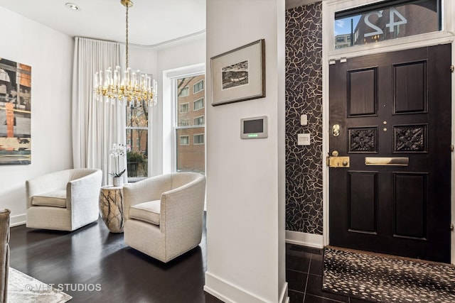 entrance foyer featuring an inviting chandelier, baseboards, and dark wood-style floors