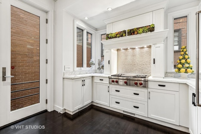 kitchen with white cabinetry, dark wood finished floors, backsplash, light stone counters, and stainless steel gas cooktop
