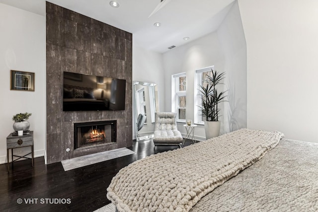 bedroom with recessed lighting, baseboards, visible vents, wood finished floors, and a tile fireplace