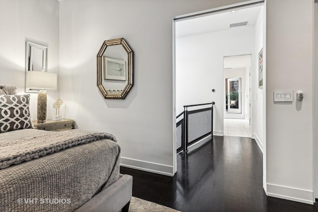 bedroom featuring baseboards, visible vents, and dark wood finished floors