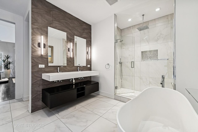 full bathroom featuring marble finish floor, visible vents, a shower stall, baseboards, and a freestanding tub