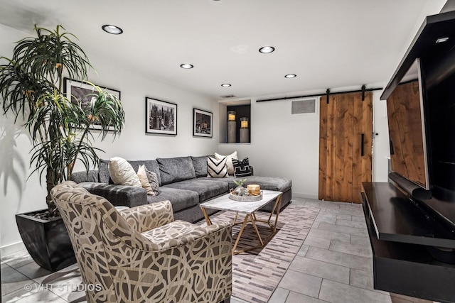living room featuring a barn door, baseboards, visible vents, and recessed lighting