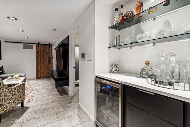 bar with a dry bar, wine cooler, a barn door, visible vents, and recessed lighting